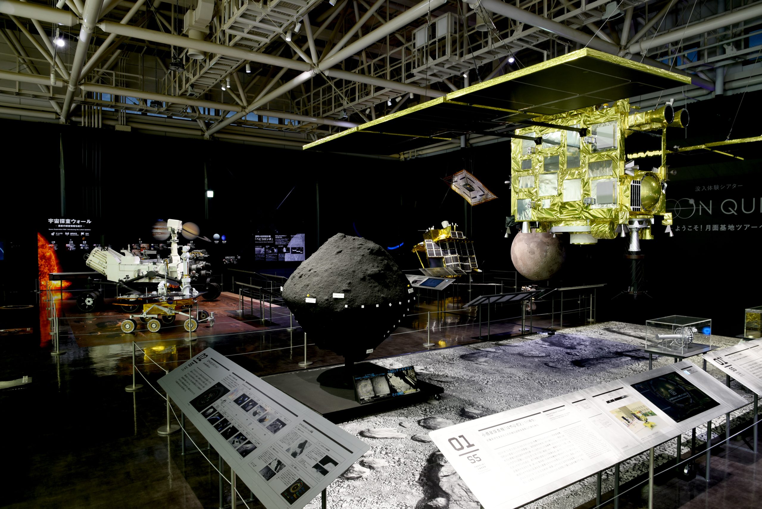 右上の金色に輝く展示が日本の小惑星探査機「はやぶさ２」の実物大模型