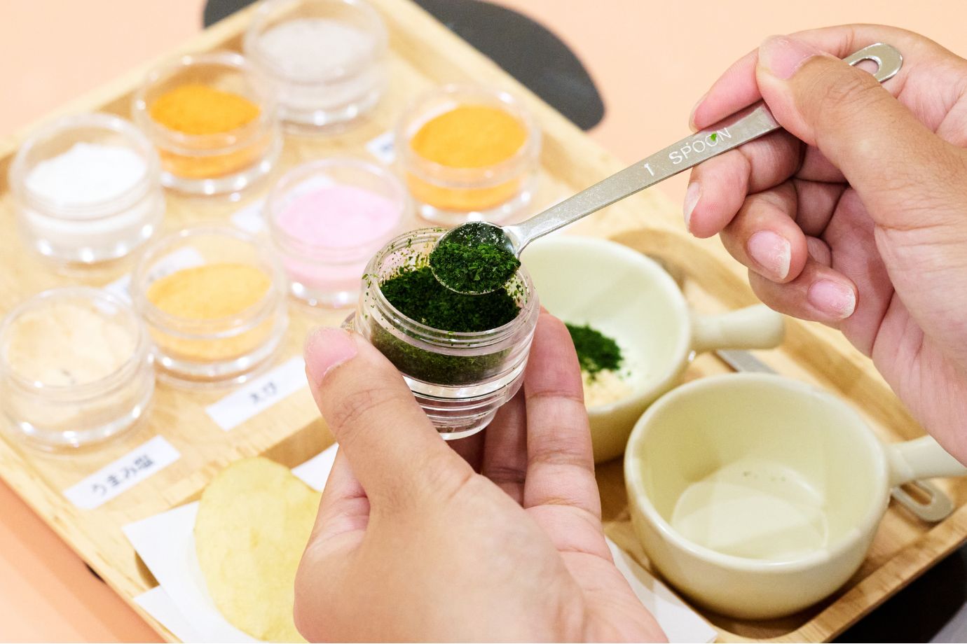見学の後は、お待ちかねのマイポテチづくり体験です。揚げたてのポテトチップスにうまみ塩を加え、好きな調味料を選んで味付けをします。